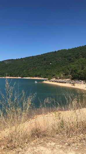 A coastal landscape with a clear blue sky, a sandy beach, and a boat on the water. - house / villa - Baudinard sur verdon (Baudinard-Sur-Verdon)