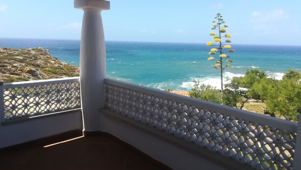 Un balcon donnant sur l’océan et agrémenté d’une colonne blanche.