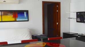 A modern room with a bed, a round table with colorful patterns, a TV on the wall, and a door. - LUXURY CASA DEL VIRREY ESLAVA APARTMENT 304, INSID (CARTAGENA DE INDIAS)