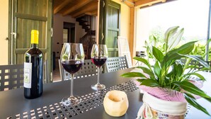 Une table avec une bouteille de vin, deux verres à vin et une plante en pot.