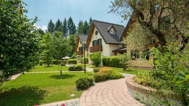 Un quartier résidentiel comprenant deux maisons, une allée pavée et une pelouse bien entretenue.