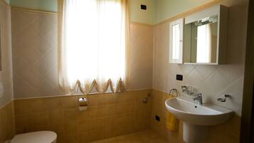 Ein Badezimmer mit Toilette, Waschbecken und Dusche.