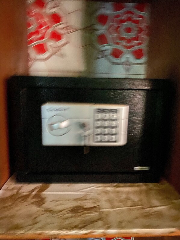 Un microondas en una cocina con un papel tapiz estampado en la pared.