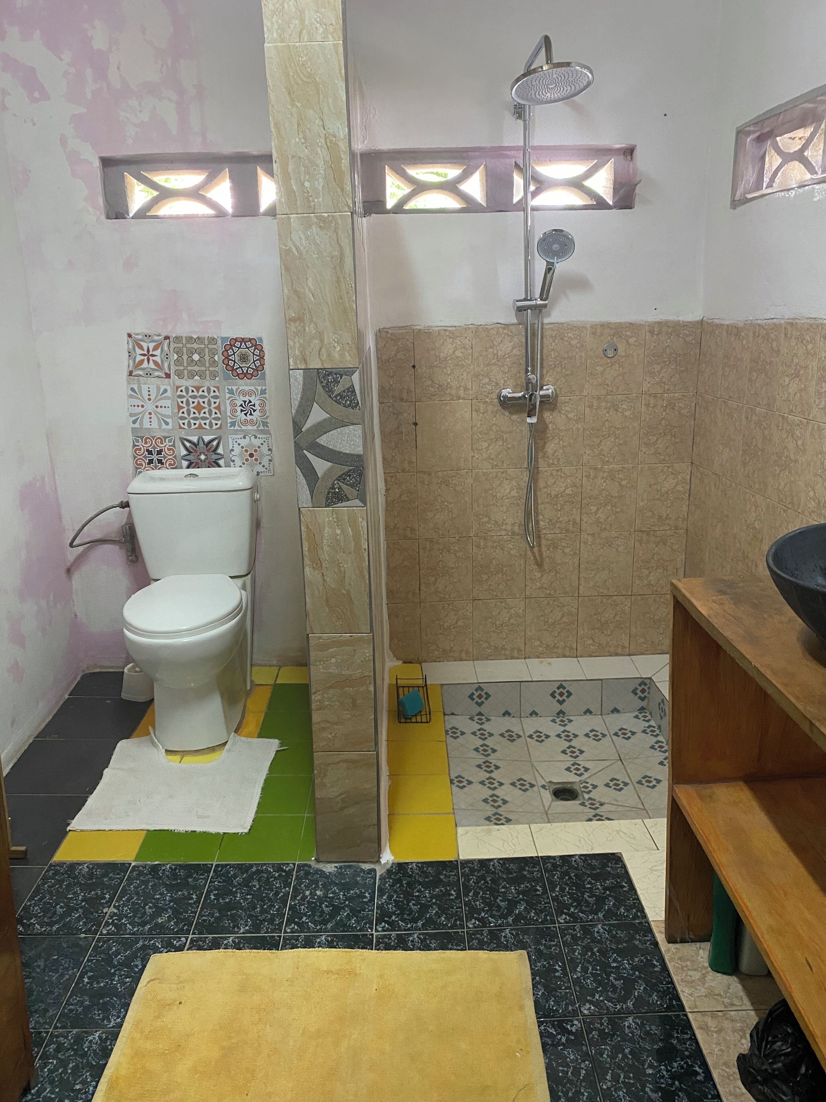 A bathroom with a toilet, shower, and sink.