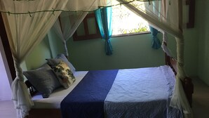 Un lit à baldaquin, avec des oreillers et une couvre-lit bleue.