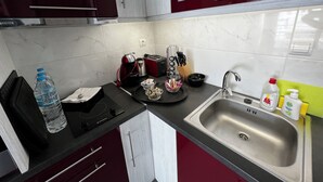 A kitchen with a stainless steel sink, a kettle, a toaster, and a water bottle. - Elea Athens Apartment (Athina)
