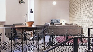 A modern living room with a dining area, a staircase, and a patterned wall. - TrastevereHome - Sales Rome (Roma)