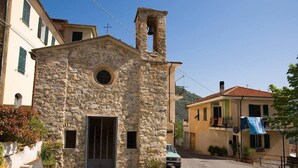 Un bâtiment en pierre doté d’un clocher, d’une porte et d’une petite fenêtre.