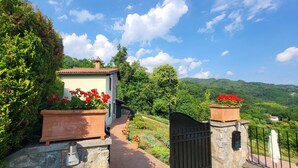 A stone pathway leading to a house with a red flower pot on each side. - Casa Roc,  Private Pool, & Arguably Best View In Barga! WIFI. Walk to rest/bar (Barga)