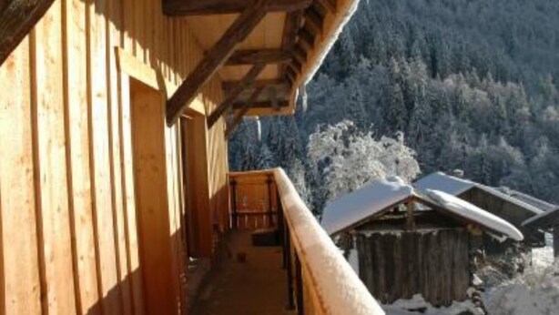 A wooden building with a balcony overlooking a snowy mountain landscape. - Apartment in a chalet of character with ski access (Montriond)