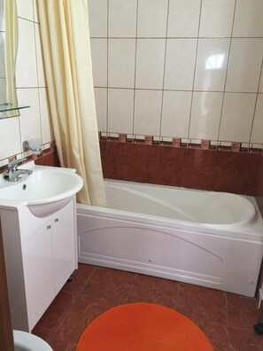 A bathroom with a white sink, a bathtub, and a shower curtain.