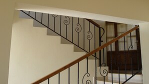 Un escalier à plusieurs niveaux, doté d’une main courante en bois et de balustrades en métal noir.
