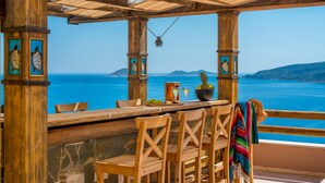 Eine hölzerne Sitzgruppe im Freien mit Blick auf das Meer.