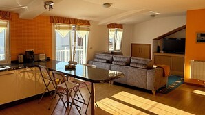Una cocina moderna con comedor, un sofá y televisor en la sala de estar.