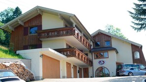A two-story building with a wooden balcony, a sign indicating a restaurant, and a parked car.