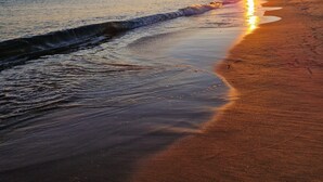 A beach at sunset with waves gently lapping the shore. - Beachfront house, Manta Rota, Algarve (Private pool, Outdoor BBQ, Free Wifi, AC ..) (Vila Nova de Cacela)