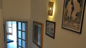 A staircase with a handrail, a door leading to another room, and framed pictures on the wall. - GARDEN VILLA DOLPHIN SEASIDE (Golfo Aranci)