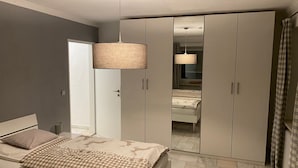 Ein Schlafzimmer mit einem Bett, einem Kleiderschrank und einem Spiegel.