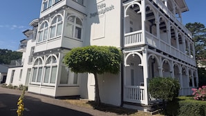 Un edificio blanco con un balcón y un letrero que dice 'Villa Glück'.