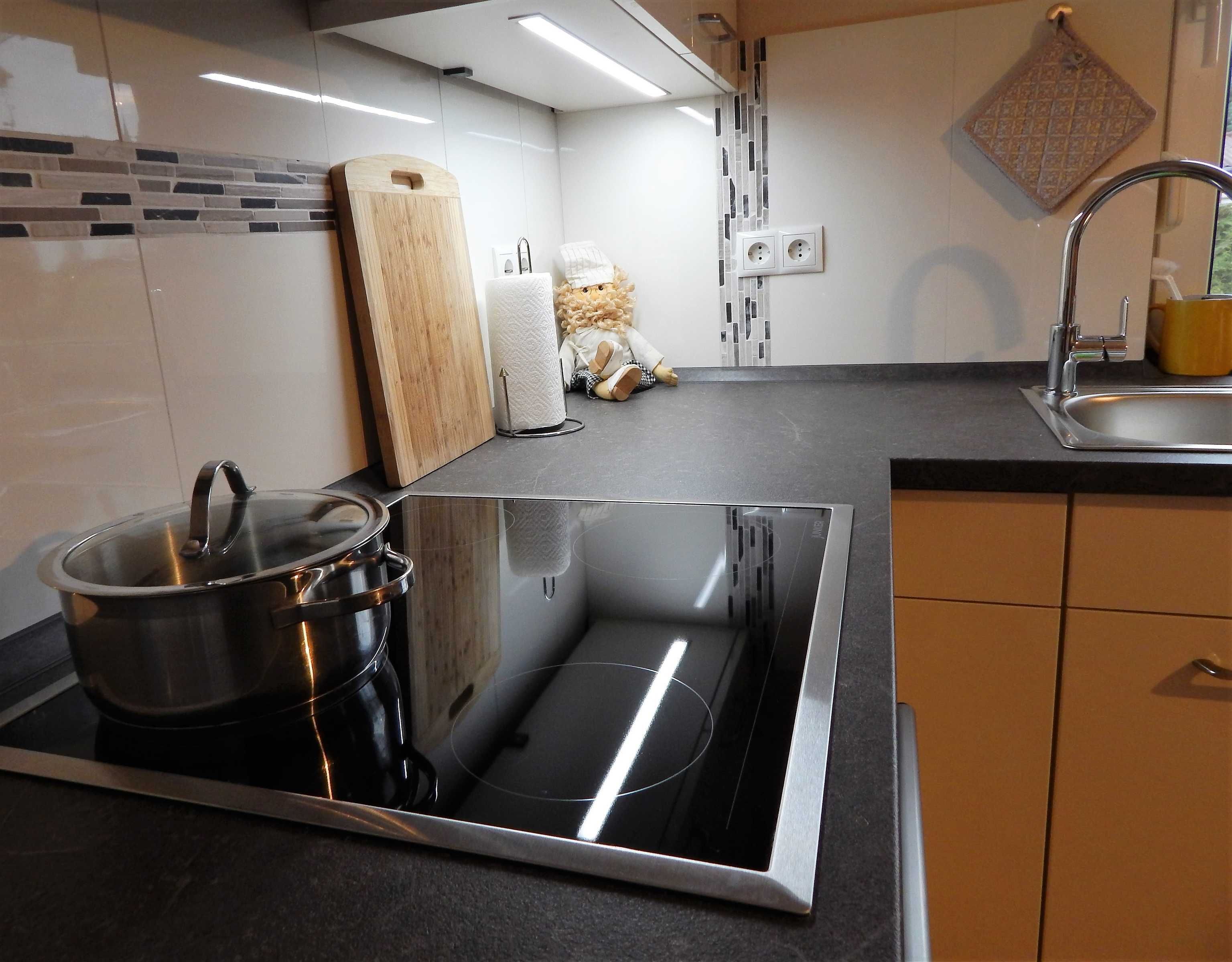 Una cocina moderna con estufa integrada, un lavamanos y una encimera.