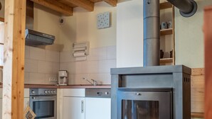 Een moderne keuken met een ingebouwde houtkachel, koffiezetapparaat en vaatwasser.