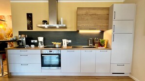 Eine moderne Küche mit Einbauofen, Kaffeemaschine und einem Holzkasten.