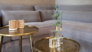 A modern living room with a sofa and two round tables, one with a vase of flowers and the other with candles. - Apartment 1 - Edersee time out (Edertal)
