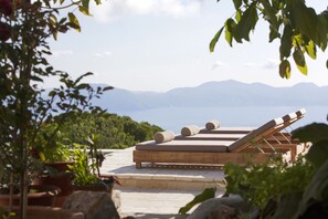 A rooftop terrace with wooden loungers and a view of the sea and mountains. - Unique, luxurious villa with infinity pool and sea view, free WiFi (Kefalonia Fiskardo)