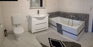 Tina con regadera, secadora de cabello, jabón, papel de baño