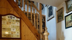 Una escalera de madera con barandilla de madera y un piano en primer plano.