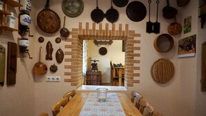 Comedor con arco de ladrillo, mesa y sillas de madera.