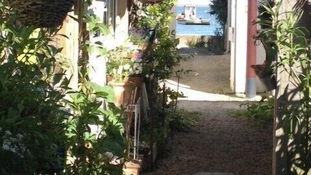 Un sendero estrecho que conduce a una zona de piscina con vistas al mar.
