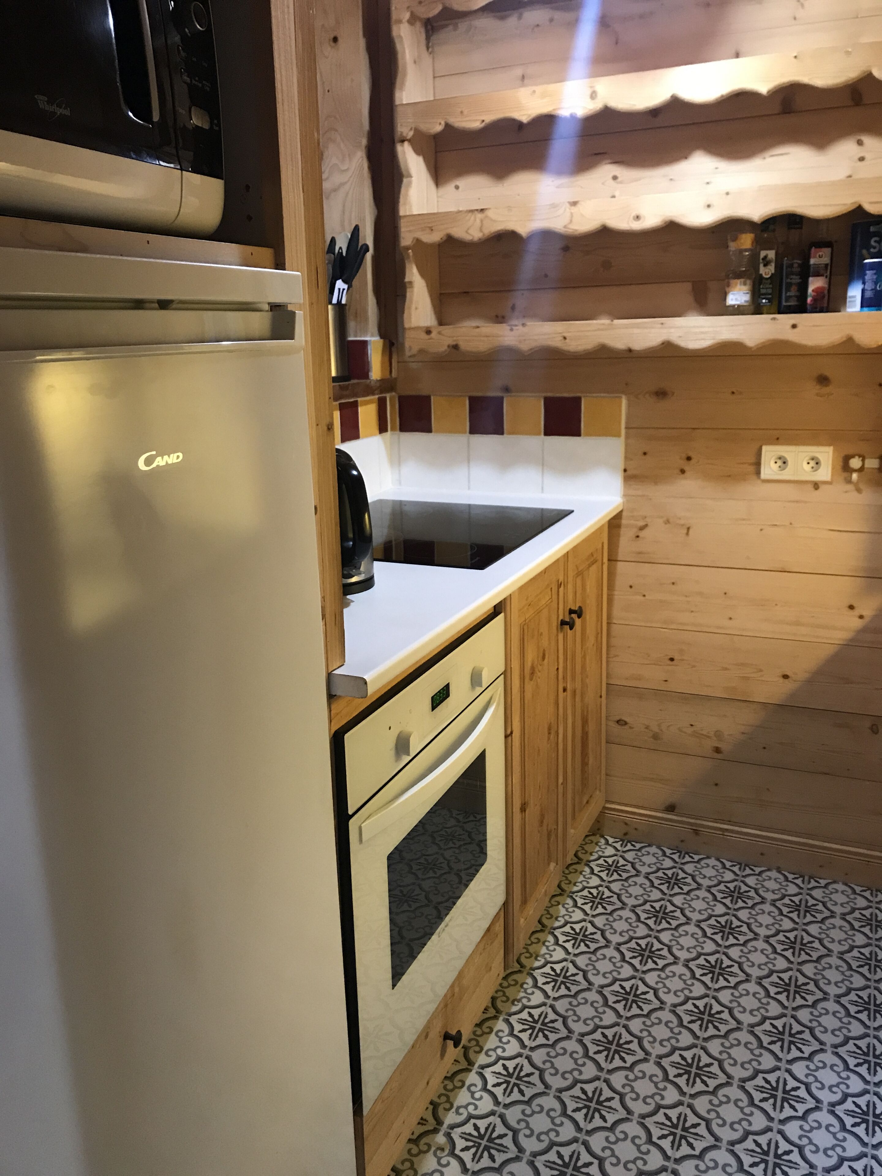 A compact kitchen with a white refrigerator, a stove, and a sink.