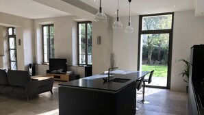 Una cocina moderna con una isla central, ventanas amplias y vistas al exterior.