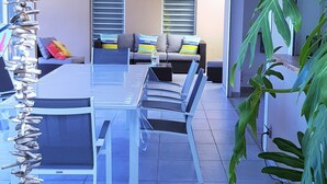 Een moderne eetruimte met een glazen tafel, stoelen en een decoratief houten beeldhouwwerk.