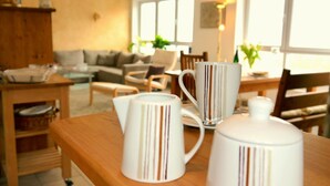A cozy living room with a wooden coffee table, a sofa, and a dining area with chairs. - Exclusive Holiday Apartment with Moselle View & Bike Garage (Bullay)
