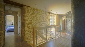 A room with a stone wall, wooden floor, and a glass railing. - 5-star villa with a pool available from August 29 to September 5 (Sainte Eulalie d'Olt)