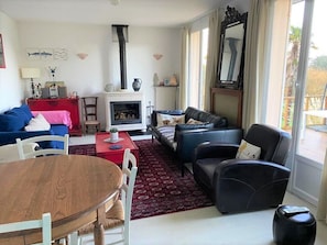 A living room with a fireplace, a dining table, and two sofas.