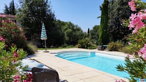 A swimming pool with a chair and an umbrella, surrounded by greenery and trees. - Villa in the countryside near Aix-en-Provence town center (Aix-en-Provence)