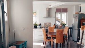 A modern kitchen with white cabinets, a dining table with wicker chairs, and a stainless steel refrigerator. - Villa in the countryside near Aix-en-Provence town center (Aix-en-Provence)