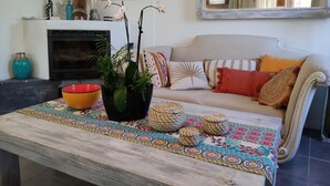 A living room with a sofa, a coffee table with a colorful mat, a fireplace, and a large mirror. - Villa in the countryside near Aix-en-Provence town center (Aix-en-Provence)