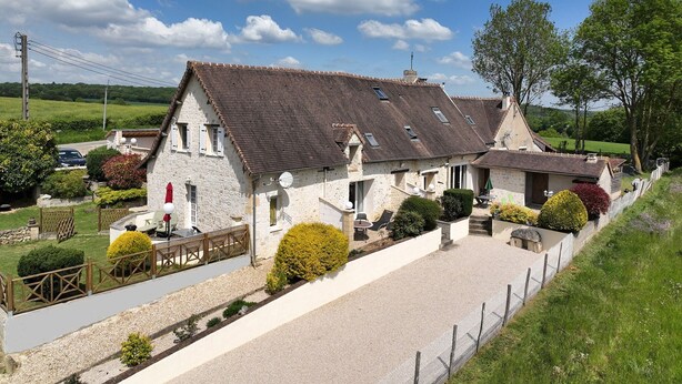 Une maison traditionnelle en pierre, dotée d’un toit à pente, d’une allée en gravier et d’un jardin clos.