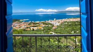 A balcony with a view of a coastal town and the sea.