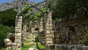An ancient stone structure with a stone staircase leading up to a wooden archway.