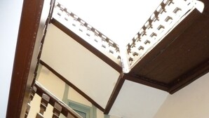 A wooden staircase with a balustrade and a view of a building with multiple windows. - T1 bis, view Nive, heart of city, ideal for couple / small family, everything on foot! (Bayonne)