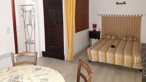 Une chambre à coucher avec un lit, une table de chevet, une lampe et un rideau.