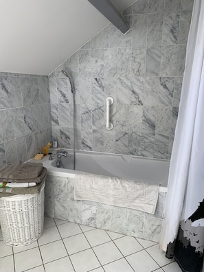 Bañera con ducha, secador de pelo, toallas, papel higiénico