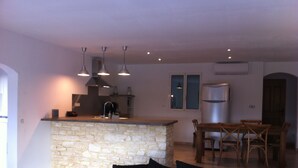 A modern kitchen with a stone island, pendant lighting, and a dining area with wooden chairs. - Very nice Mazet with pool and panoramic views of the Cevennes (Saint-Privat-de-Champclos)
