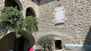 Un edificio in pietra con portali ad arco e una piccola finestra.