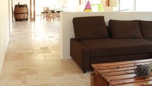 A spacious living area with a wooden ceiling, a brown sofa, a wooden coffee table, and a dining area in the background. - Large villa with swimming pool in a peaceful setting in the Baronnies provençales (Verclause)